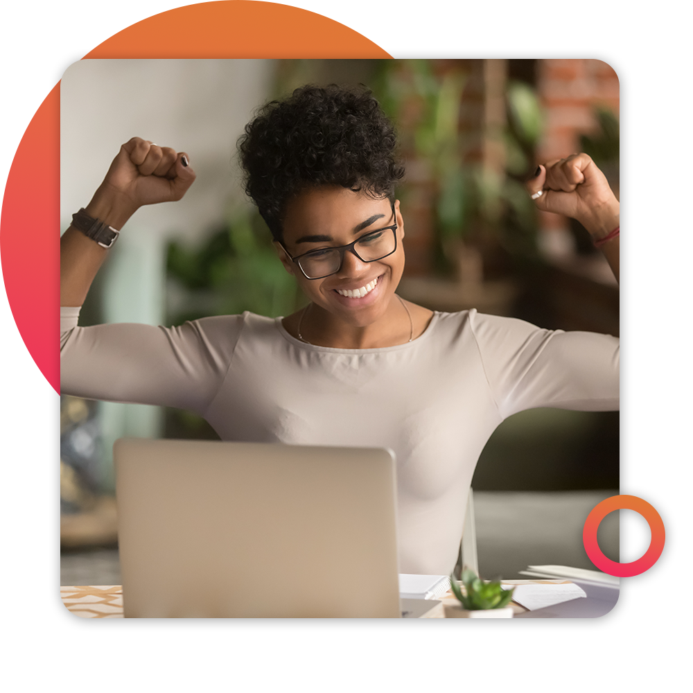 happy woman with arms raised in front of laptop